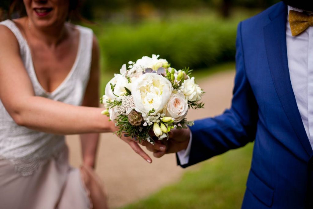 Couple de mariés tenant un bouquet de mariage Au Ver'tige